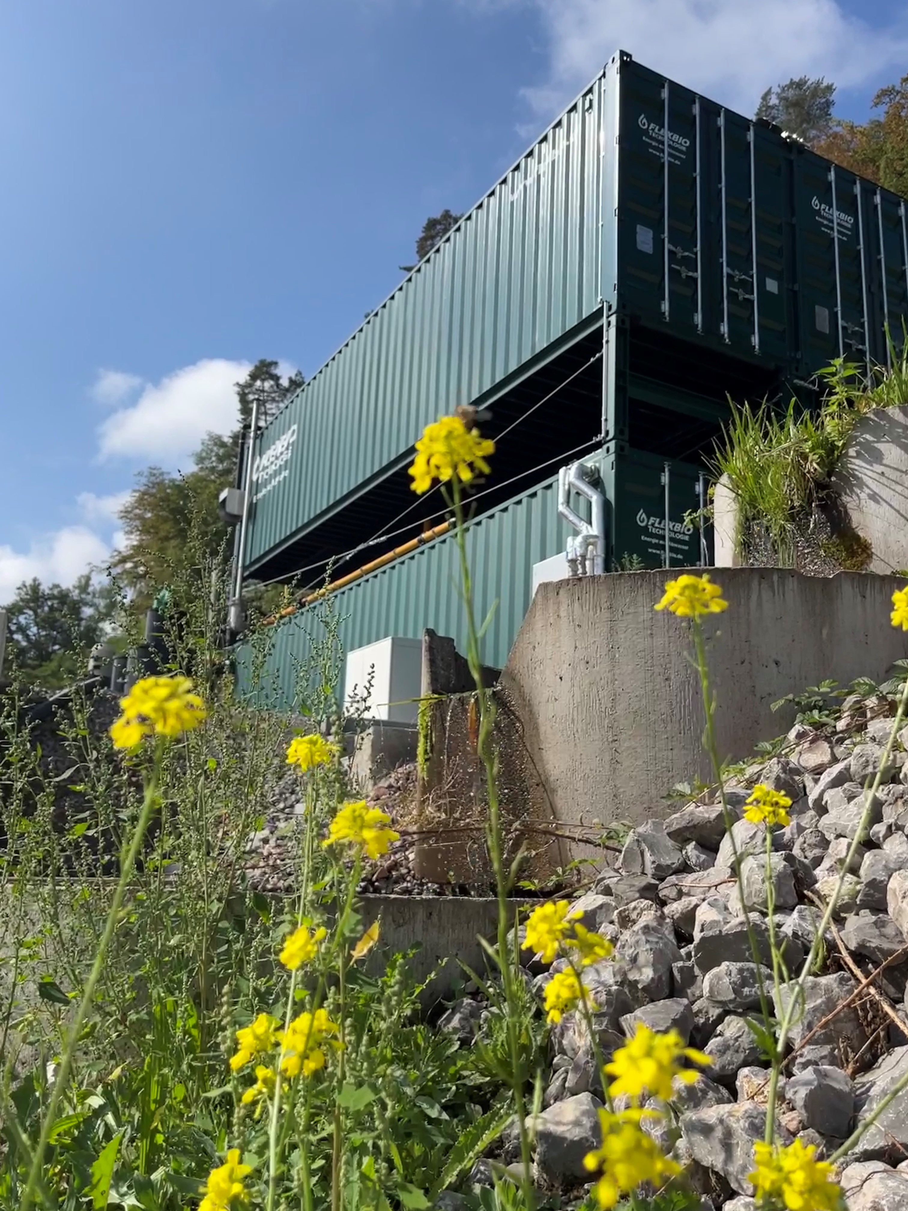 Modulare FlexBio-Containeranlage an einem schwer zugänglichen Standort in Hanglage zur kompakten Abwasserbehandlung und Biogasnutzung.